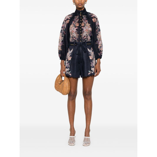 Woman wearing Zimmermann Rhiannon Billow blouse in navy blue with paisley print, long sleeves, and elasticated cuffs.